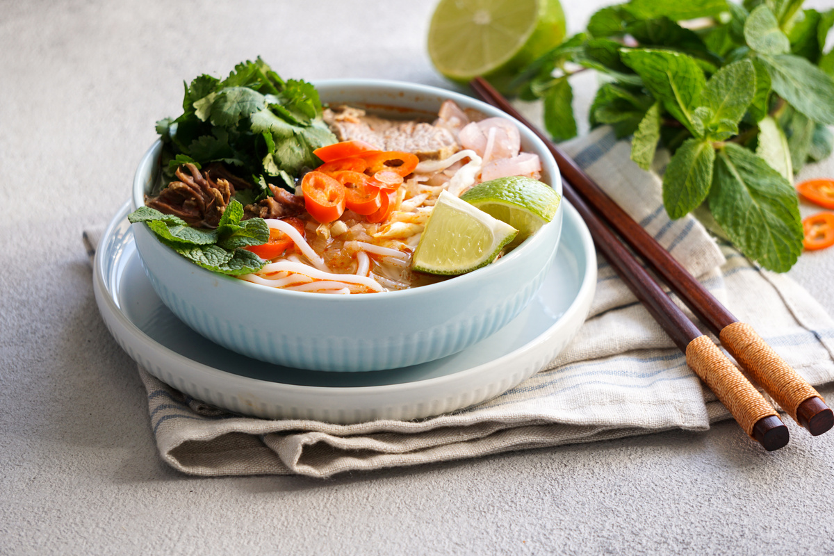 Bun Bo Hue in Bowl and Chopsticks on Table Napkin