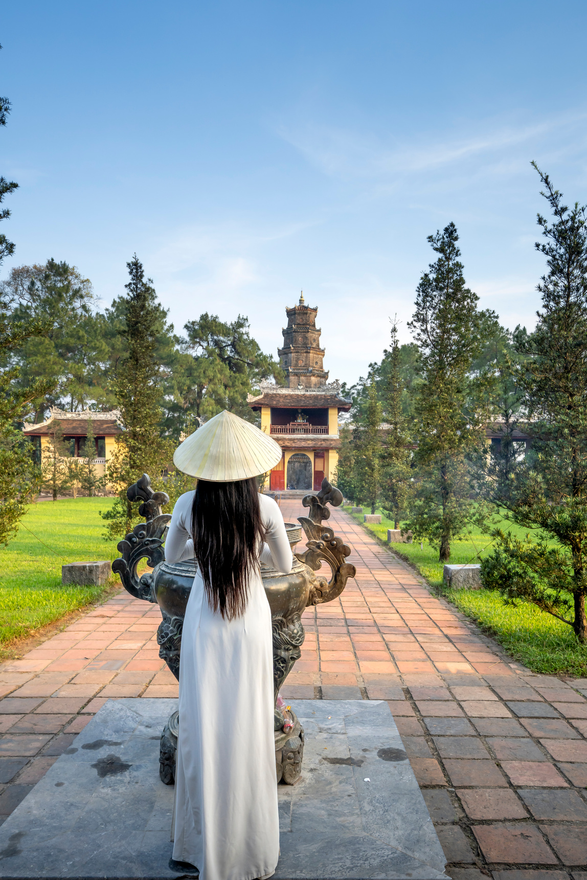 Anonymous woman standing against temple in Vietnam